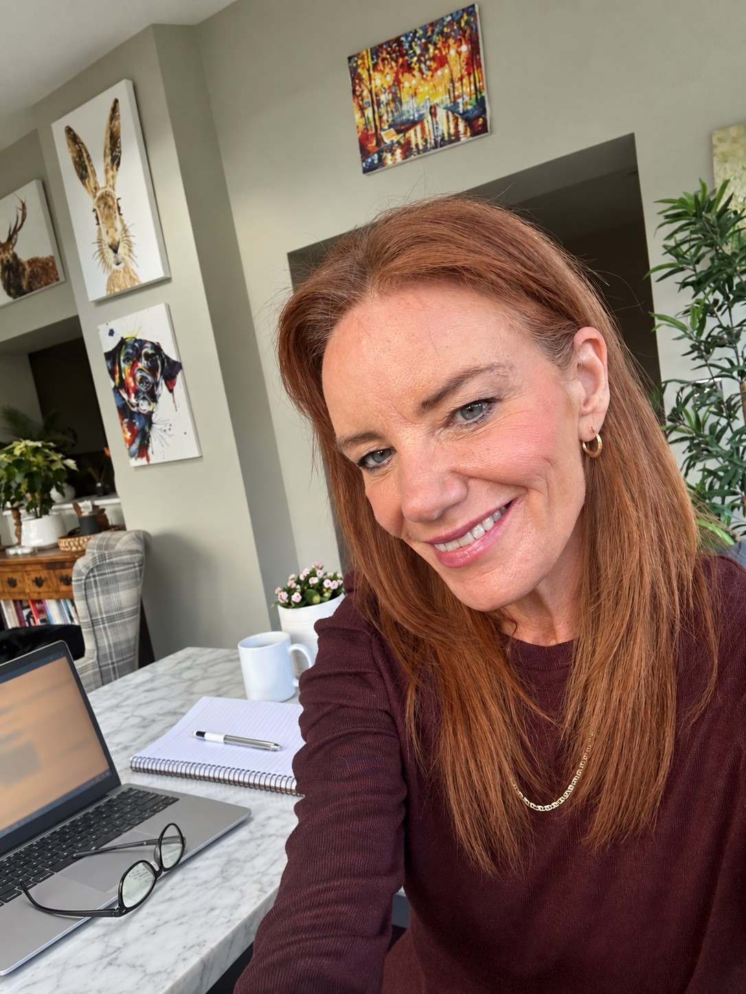Karen working at her desk with a laptop and notebook